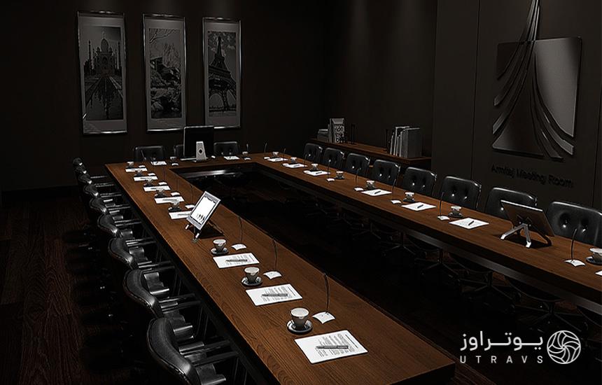سالن کنفرانس برج آرمیتاژ مشهد؛ میز چوبی سه‌طرفه قهوه‌ای‌رنگ که دورتادورش صندلی‌های چرمی مشکی قرار دارد.